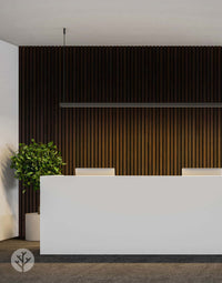 Smoked Oak Acoustic Slat Wood Wall Panels in modern interior design with a white reception desk and green plant accent.