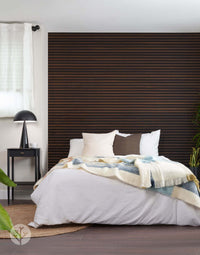 Bedroom with smoked oak acoustic slat wall panels and cozy bedding, showcasing stylish interior wall panelling.