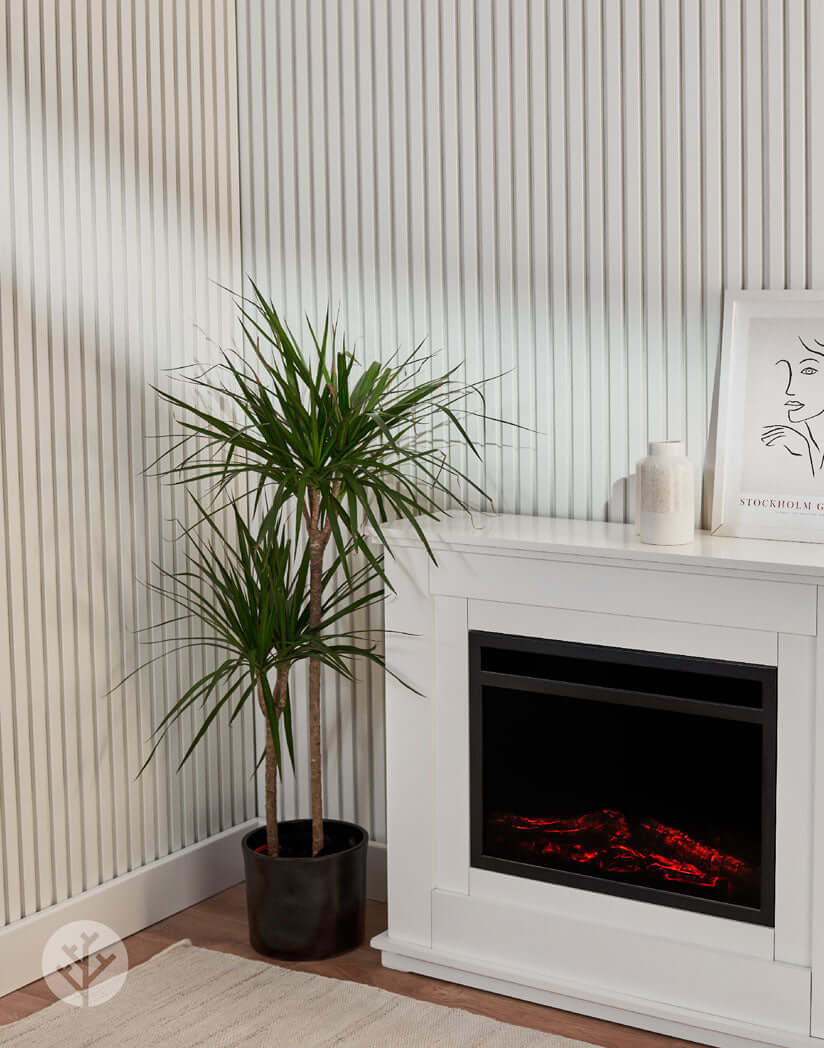 Modern living room with Snow White Acoustic Slat Wall Panels, plant, and fireplace creating a serene interior atmosphere.