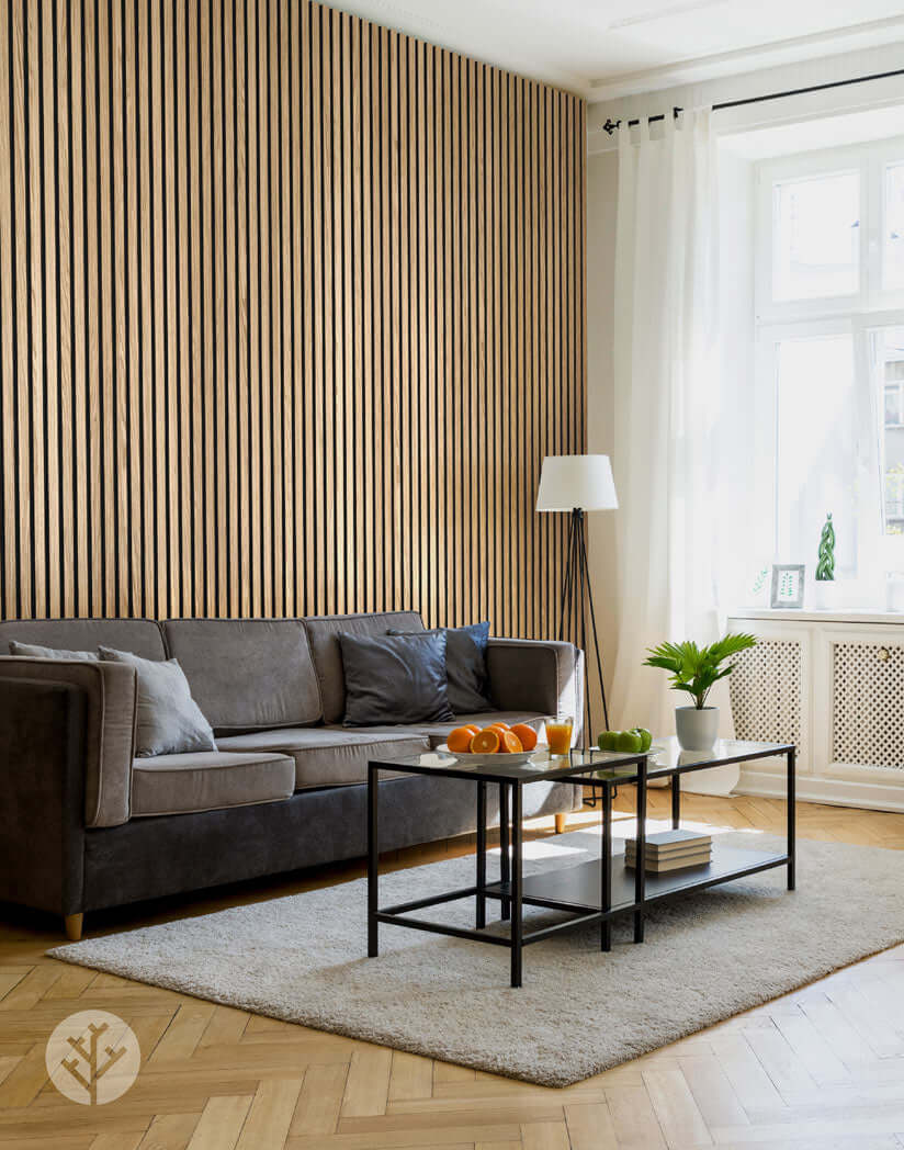 Modern living room with natural oak acoustic slat wood wall panelling, grey sofa, and a black coffee table for elegant interior design.