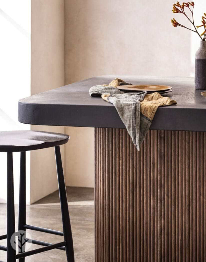 Walnut Mini-Ridge flexible tambour wood panel on a modern kitchen island with a black stool and decorative items.