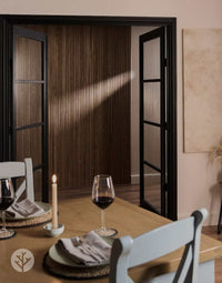 Dining room featuring Walnut Ridge Flexible Tambour luxury wall panels and elegant table setting with wine glasses.