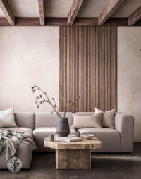 Luxury interior with Walnut Ridge Flexible Tambour Wood Panels on wall, featuring modern sofa and wooden coffee table.