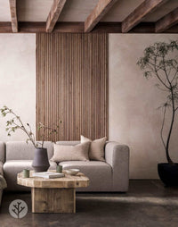 Living room with Walnut Ridge Flexible Tambour Wood Panel accent wall, featuring a modern sofa and rustic coffee table. Luxury wall panels decor.