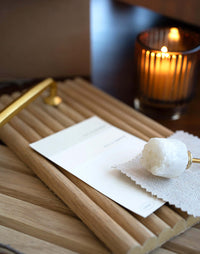 Flexible tambour wood panels sample box with card, rock candy, and candle, showcasing design and decorative elements.