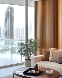 Contemporary living room with natural oak acoustic slat wall panels, enhancing interior aesthetics and sound quality.