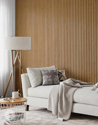 Natural oak grey felt acoustic wood wall panels in modern interior with sofa and lamp.
