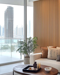 Contemporary living room with natural oak acoustic slat wall panels, enhancing interior aesthetics and sound quality.
