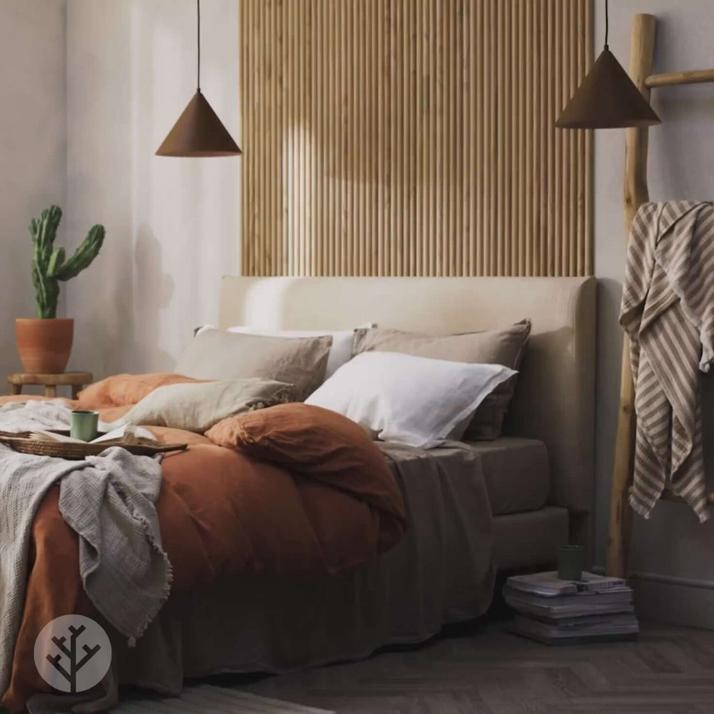 Luxury bedroom with Oak Ridge Tambour Wood Panel accent wall, beige bedding, and soft lighting for a cozy ambiance.